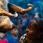 A girl interacting with a sloth at Ripley's Aquarium of Myrtle Beach.