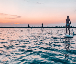 paddle boarders at sunrise