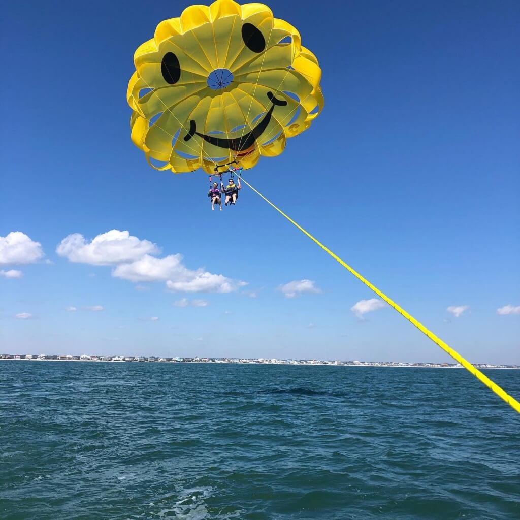 Two people parasailing high over the Atlantic Ocean with Express Watersports in Myrtle Beach