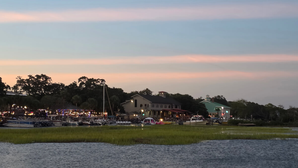 Murrells Inlet MarshWalk at dusk with waterfront restaurants and boats.