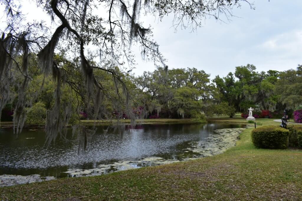 Peaceful pond surrounded by moss-draped oaks at Brookgreen Gardens in South Carolina, reflecting the natural beauty of the Lowcountry and Gullah heritage.