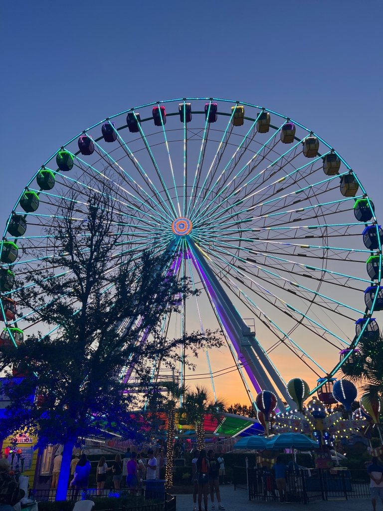 Broadway 360 Observation Wheel lit up at night with colorful lights in Myrtle Beach.