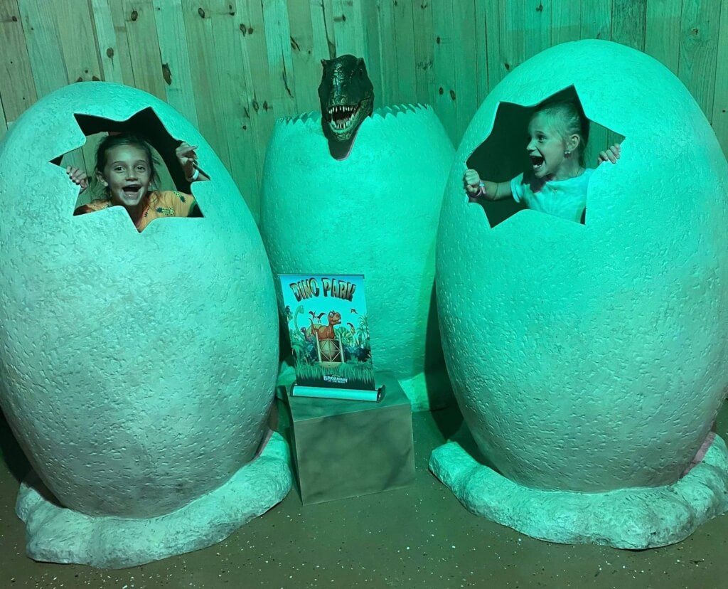 children smiling inside life-sized dinosaur eggs at Dino Park