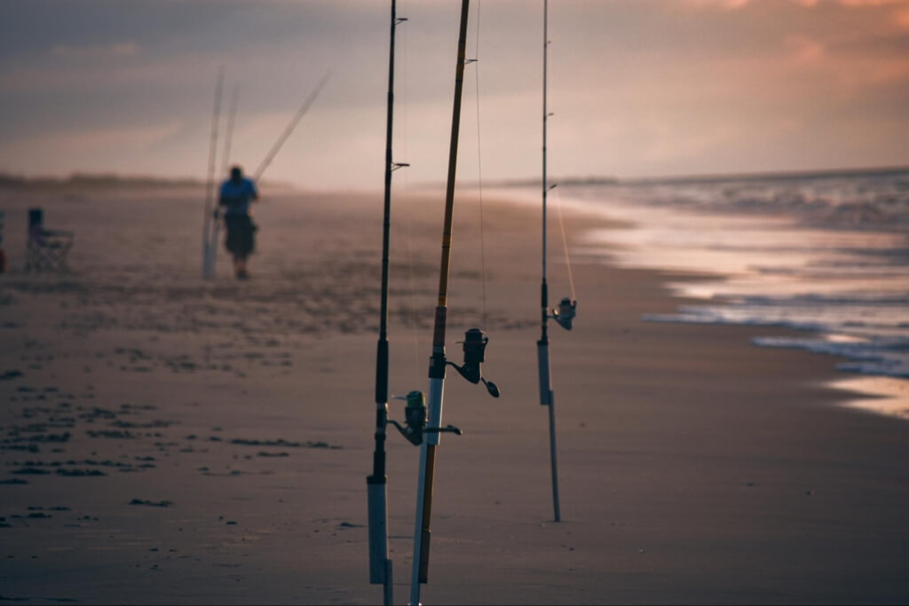 fishing poles stand in the sand on the Myrtle Beach shoreline