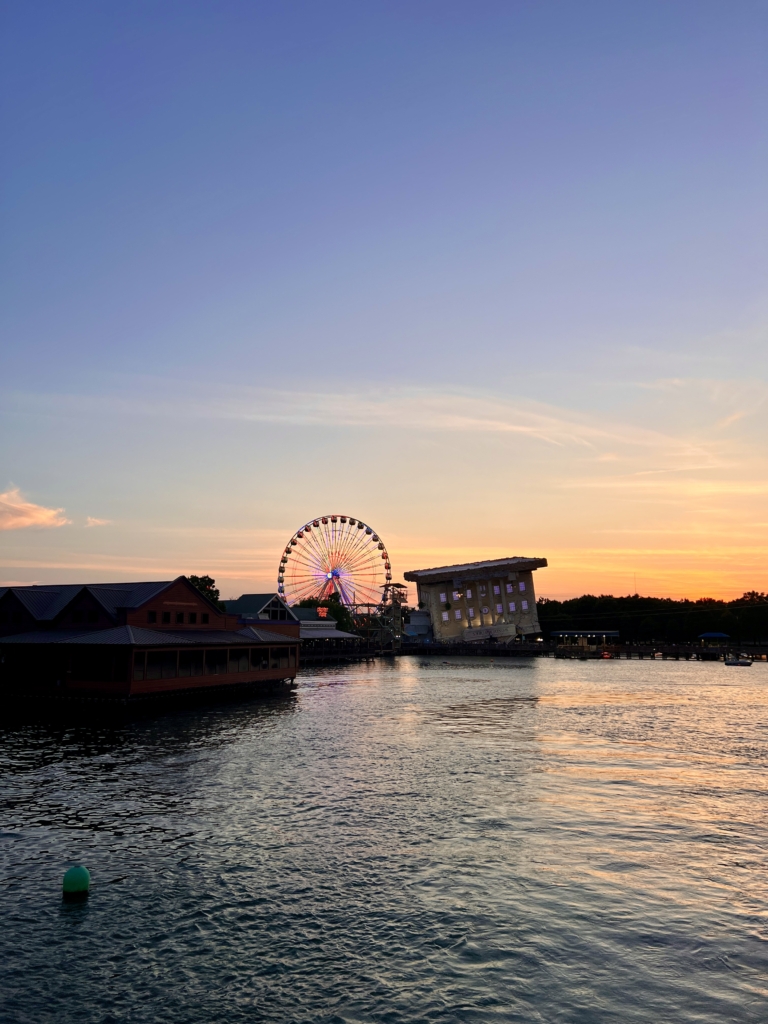 Myrtle Beach sunset with Ferris wheel, waterfront buildings, and calm waters, perfect for family vacations and romantic getaways.