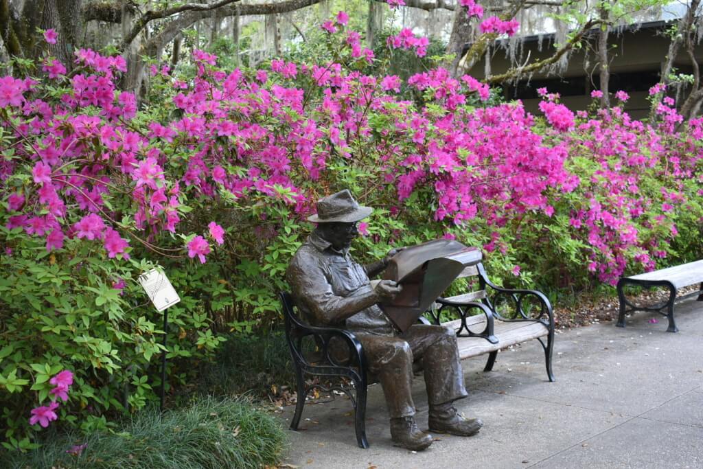 Statue surrounded by vibrant pink azaleas at Brookgreen Gardens, a romantic and peaceful spot for couples visiting Myrtle Beach.