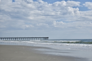 Quiet winter shoreline in Myrtle Beach with a pier in the distance.