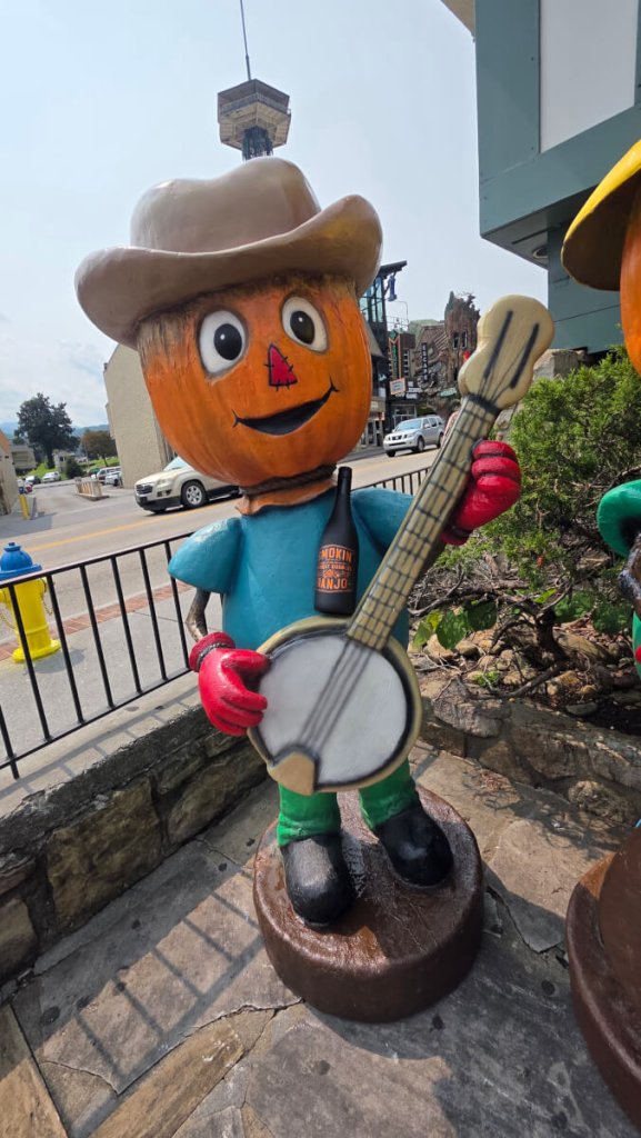 Pumpkin and scarecrow decorations along Gatlinburg Parkway during fall
