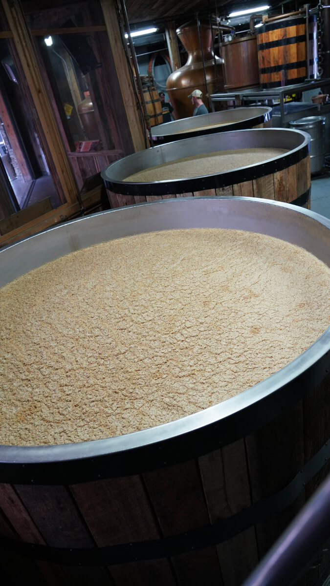 Fermentation tanks and copper stills inside a moonshine distillery.