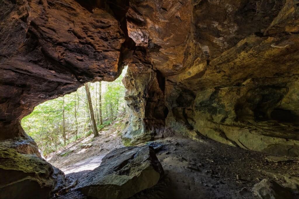 the mouth of Alum Cave leads to a forested hiking trail