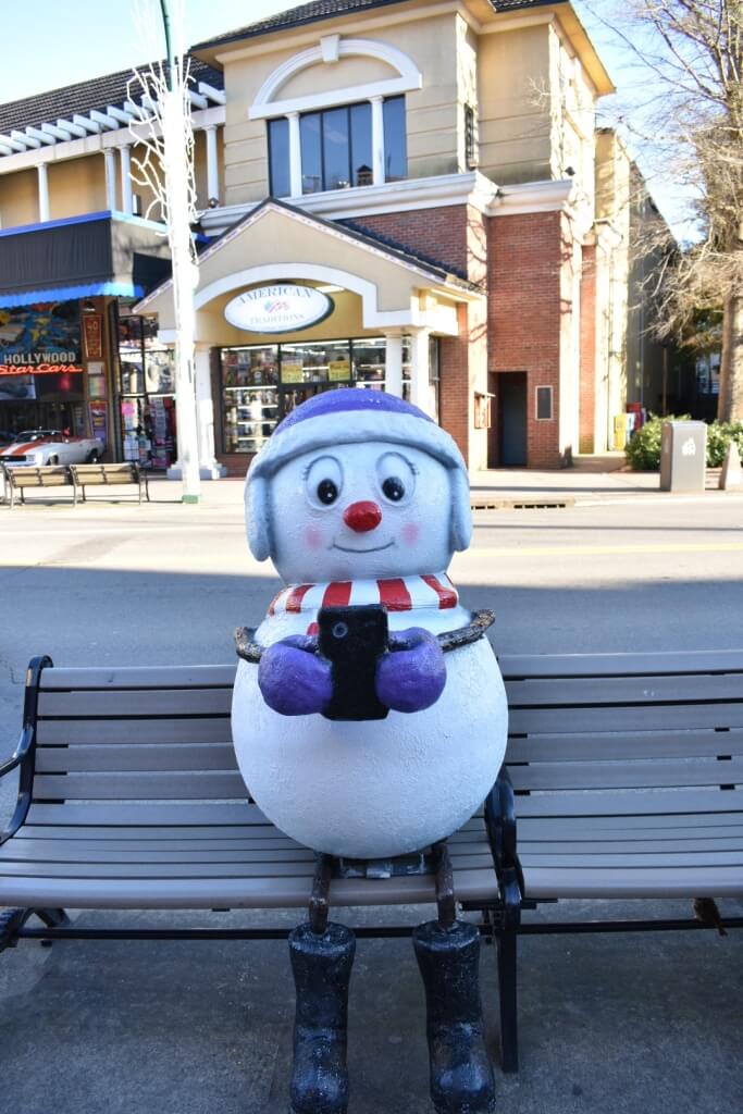 Life size SnowPerson statue sitting on a bench in downtown Gatlinburg during the SnowPeople Scavenger Hunt.