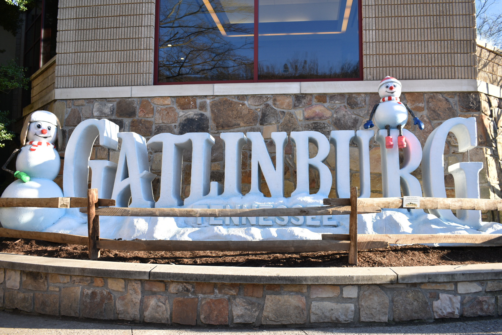 Gatlinburg Tennessee sign decorated with cheerful SnowPeople statues during Gatlinburg Winter Magic.
